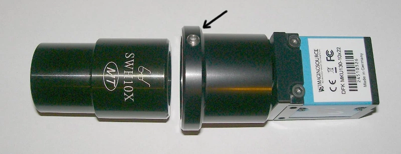 Abb. 2: Kamera mit verschraubtem Tubus und mitgeliefertem Okular, Pfeil: Inbus-Schraube zum Fixieren und Lösen des Okulars.